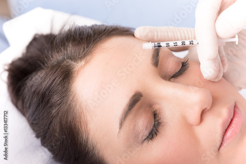 Close-up hands of cosmetologist giving woman cosmetic injection