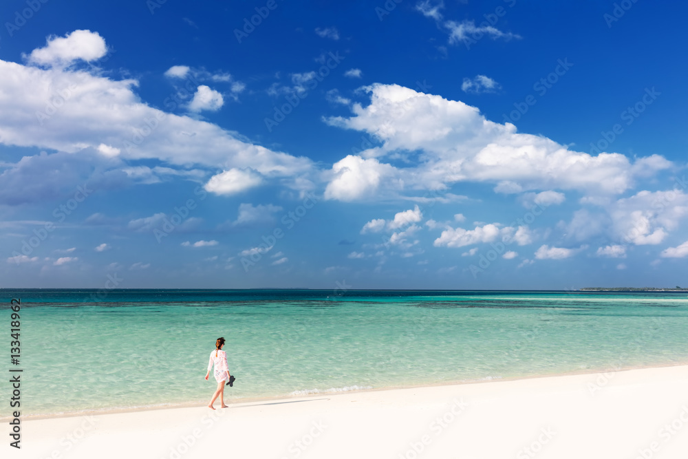 Woman walking on tropical beach in Maldives