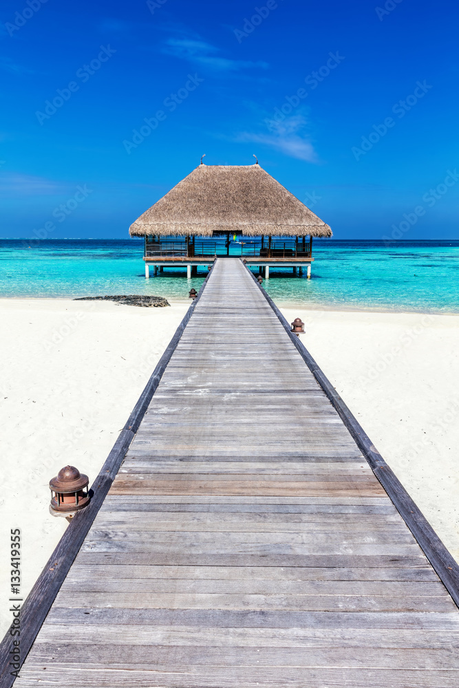 Wooden jetty leading to relaxation lodge. Maldives islands