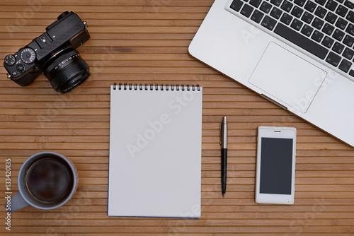 Vintage hipster wood top Desk, the laptop and a Cup of coffee, a camera, a leather notebook, a telephone