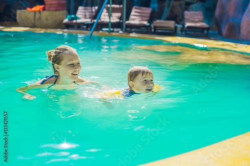 Young cheerful mother and son in a swimming pool