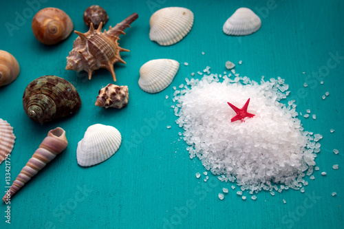 Spa concept. Seashells and  sea salt  on blue wooden background