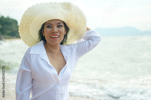Sexy woman in white shirt posing on the beach