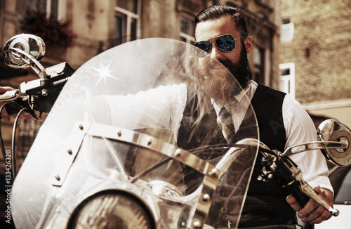 Serious Bearded Biker Man Sitting on a Motorcycle © zwiebackesser