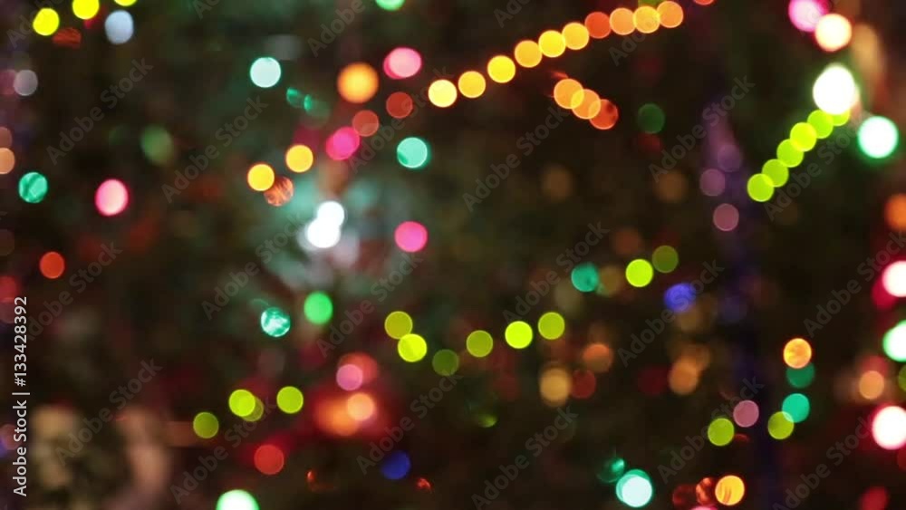Christmas tree with colorful bokeh and christmas lights..Christmas and new year decoration. Abstract bokeh holiday background. Blinking garland. Christmas lights twinkling.