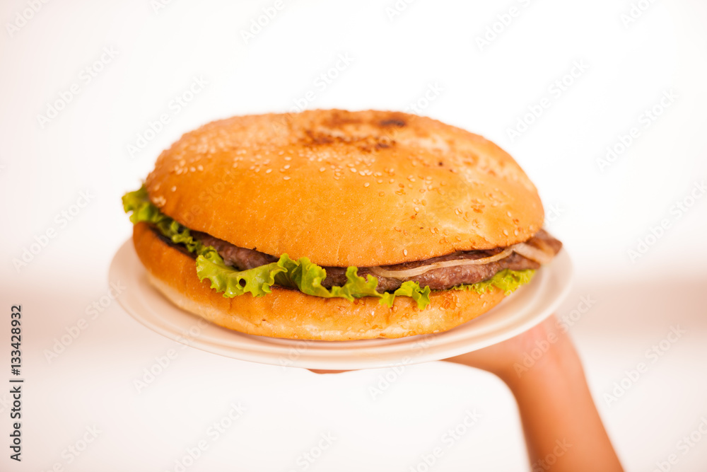 Woman eats hamburger isolated over white background Woman eats hamburger isolated over white background
