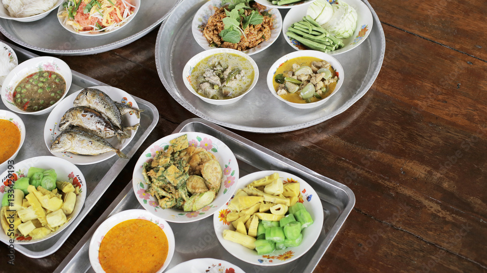 Set of Thai food Fried Mackerel with Shrimp Paste Sauce, Fried Egg with Climbing Wattle, Chicken Green Curry, Spicy minced pork, Noodles rice and curry, Stir-fried noodles, bamboo-shoot salad on tray 