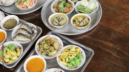 Set of Thai food Fried Mackerel with Shrimp Paste Sauce, Fried Egg with Climbing Wattle, Chicken Green Curry, Spicy minced pork, Noodles rice and curry, Stir-fried noodles, bamboo-shoot salad on tray 