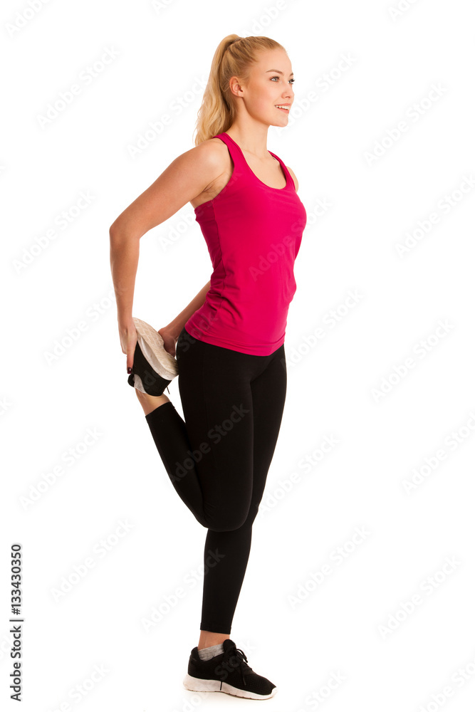 Fototapeta premium Beautiful young woman stretches leg isolated ovwer white backgro