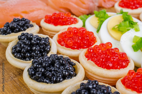 Tartlets with caviar, salted salmon and eggs.