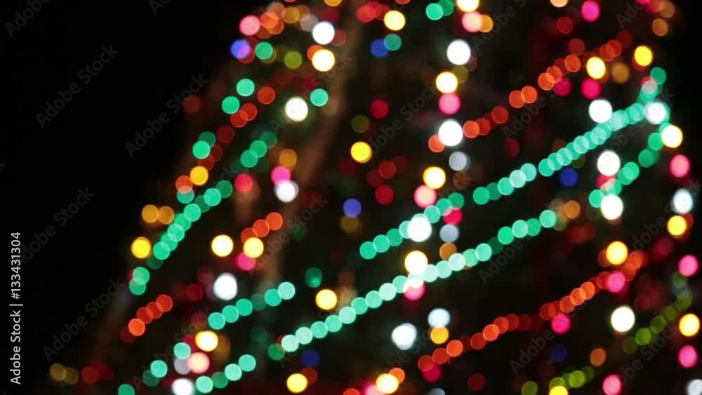 Christmas tree with colorful bokeh and christmas lights..Christmas and new year decoration. Abstract bokeh holiday background. Blinking garland. Christmas lights twinkling.
