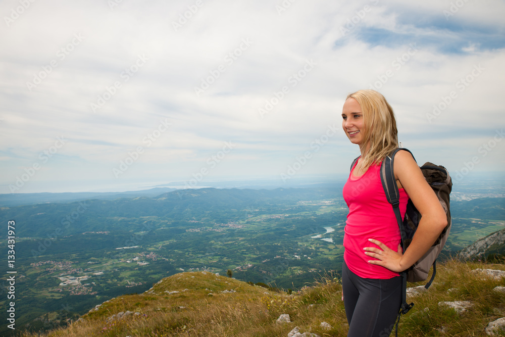 Trekking - woman hiking in mountains on a calm sumer day