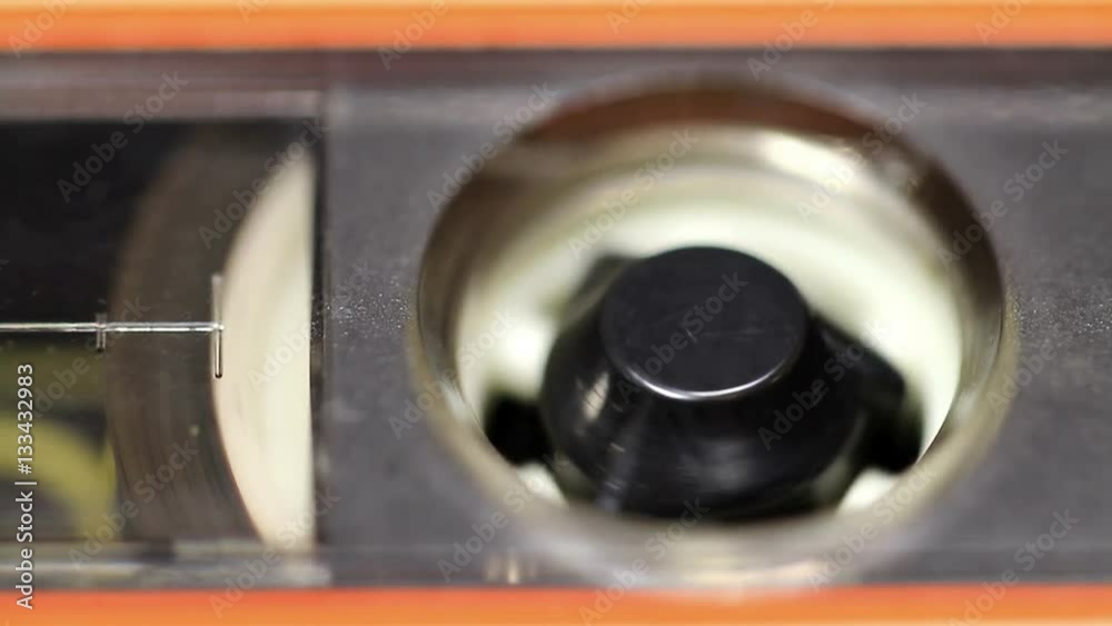 Close up of audio cassette tape in use sound recording in a cassette player. Cassette Tape Macro Close up of audio cassette tape in use sound recording in a cassette player. Cassette Tape Macro