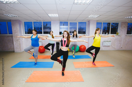 smiling people with coach dancing zumba in gym or studio