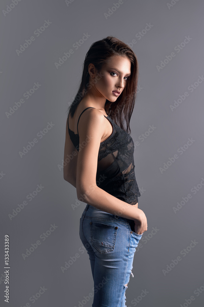 Sexy girl in lace top and ripped jeans in profile Stock Photo | Adobe Stock