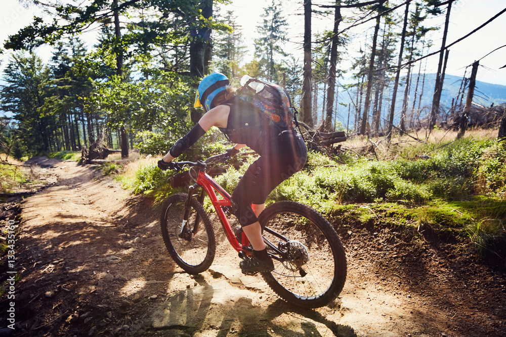 Woman riding downhill on MTB mountain bike on the track