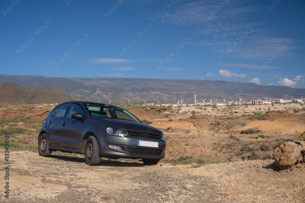the car in the desert in the background of mountains with windmills. Transportation on Tenerife island. Canary islands