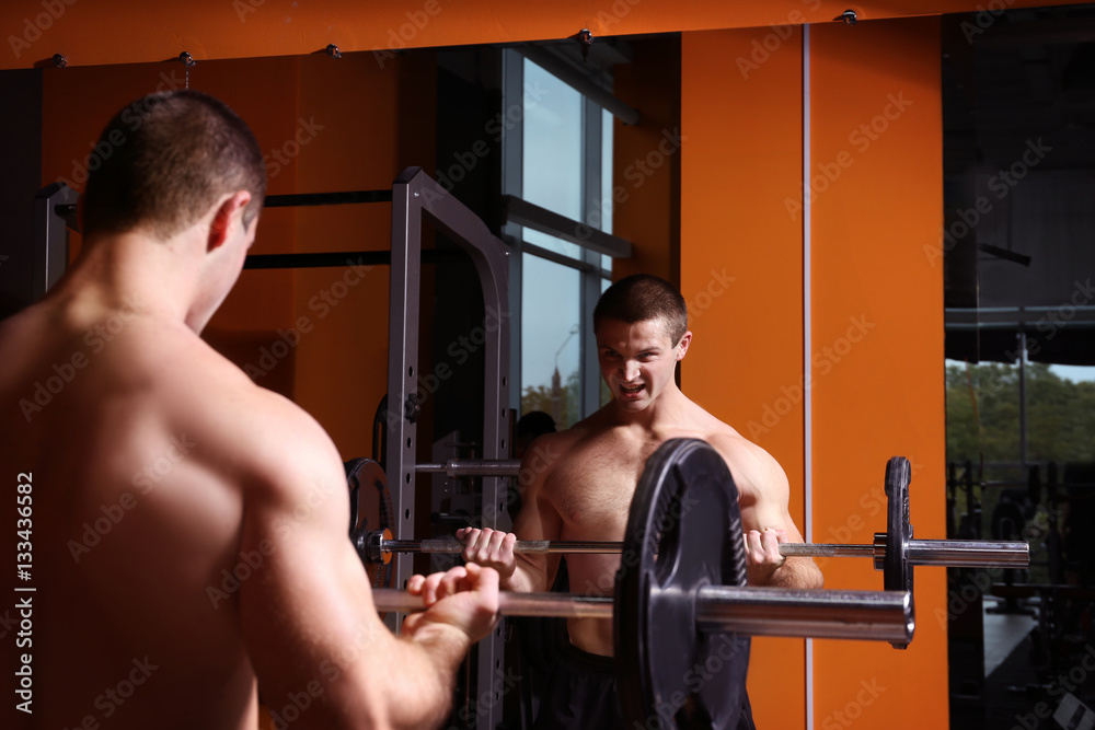 Young handsome man with barbell training in gym Young handsome man with barbell training in gym