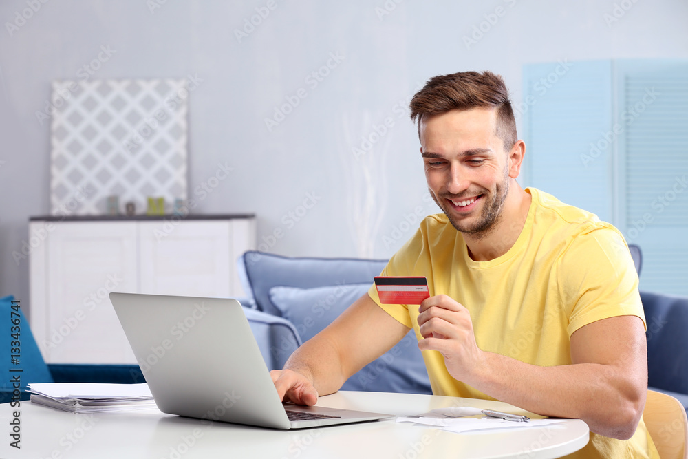 Handsome young man filling-in income tax declaration at home Handsome young man filling-in income tax declaration at home