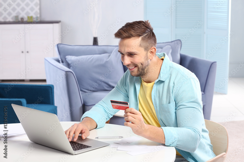 Handsome young man filling-in income tax declaration at home Handsome young man filling-in income tax declaration at home