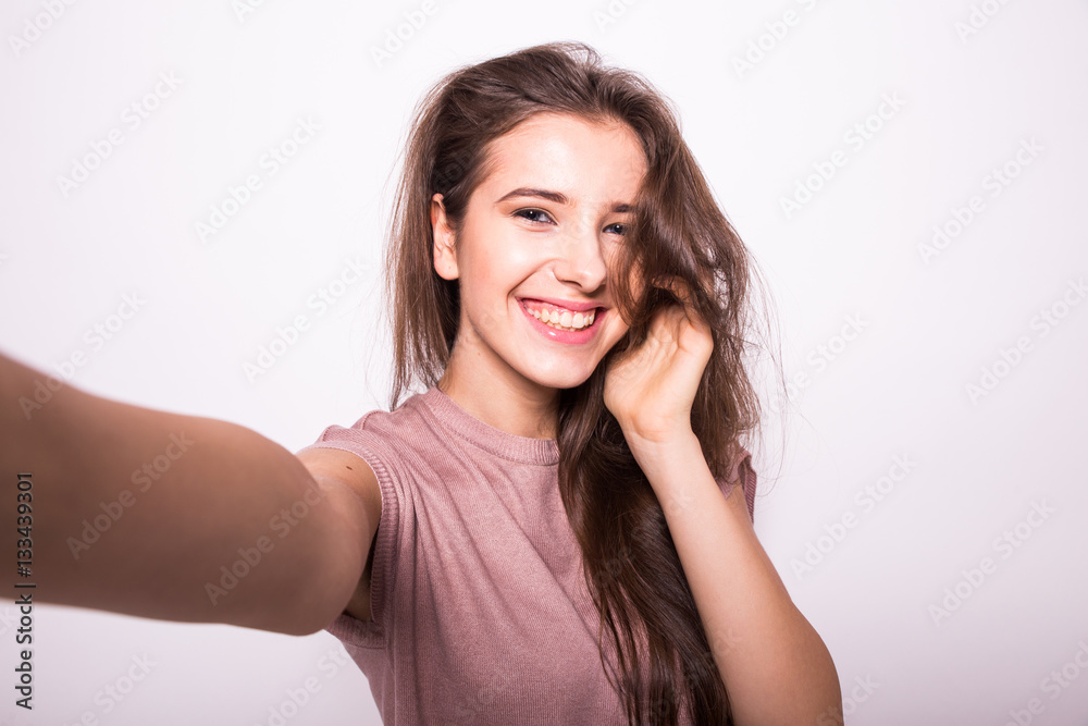 Young happy smile girl take selfie on white background Young happy smile girl take selfie on white background