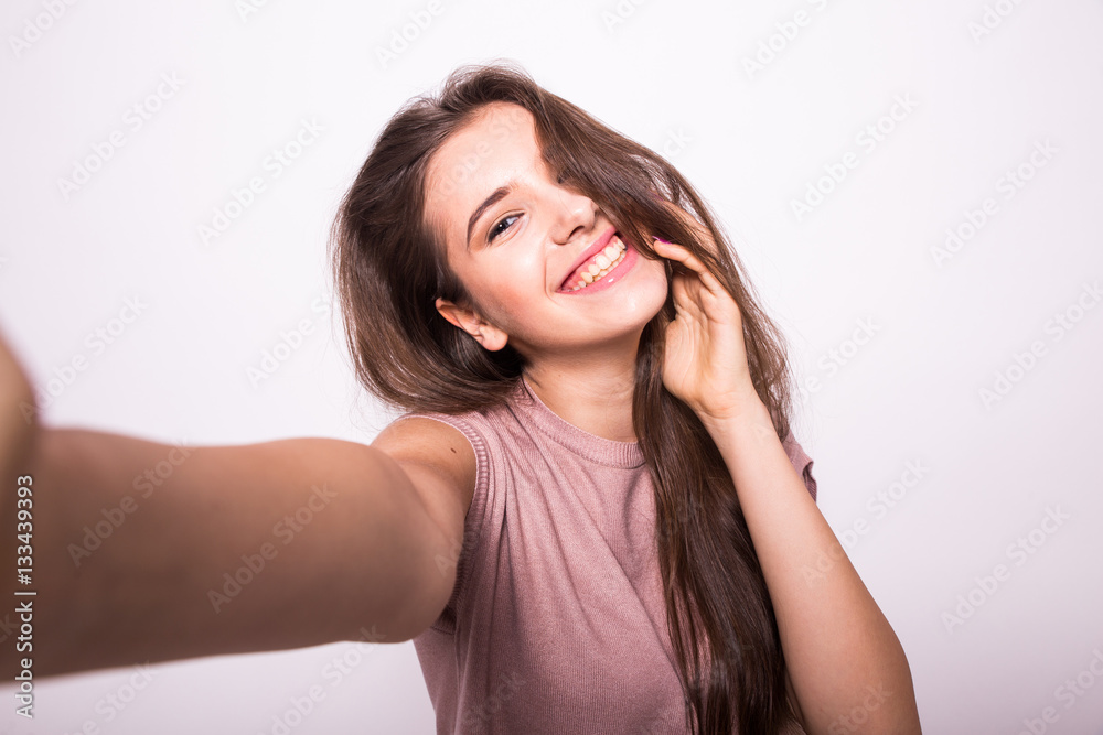 Young happy smile girl take selfie on white background Young happy smile girl take selfie on white background