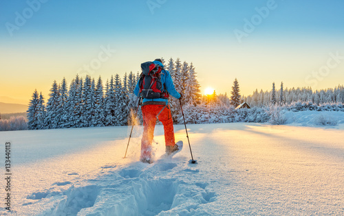Tablou canvas Snowshoe walker running in powder snow