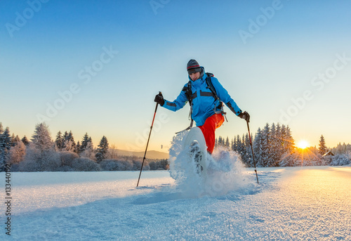 Snowshoe walker running in powder snow photo