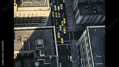 vintage panorama on seventy from Empire State Building top, aerial view of typical yellow taxis in the Manhattan traffic. New York, United States of America - circa 1970.