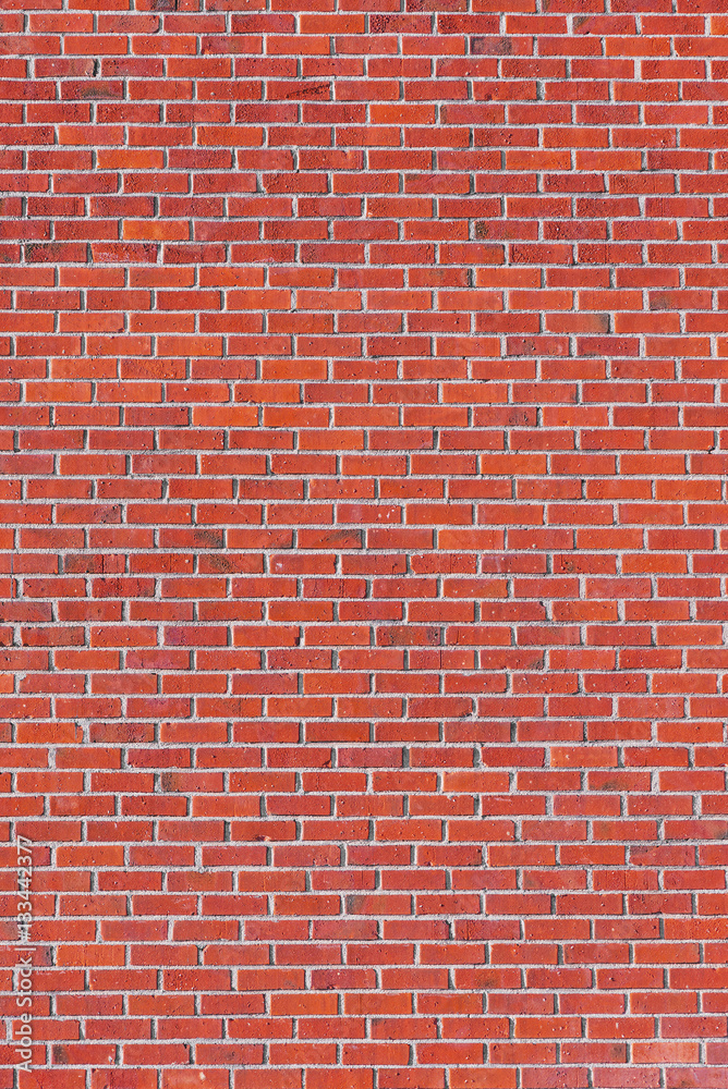 Fototapeta premium Red brick wall with many tiles on a building facade