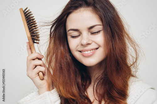 girl with a comb in his hand on a white background distressed hair