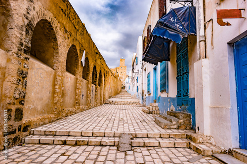 A street in Medina in Sousse, Tunisia. Magical space of medieval town with colorful walls and stone pavement. photo