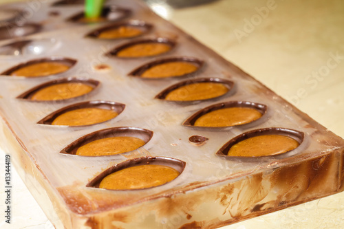Filled chocolate shells arranged in a confectionery mold