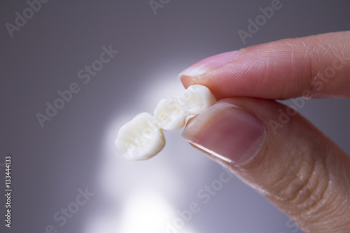 Woman hand pointing of false teeth photo