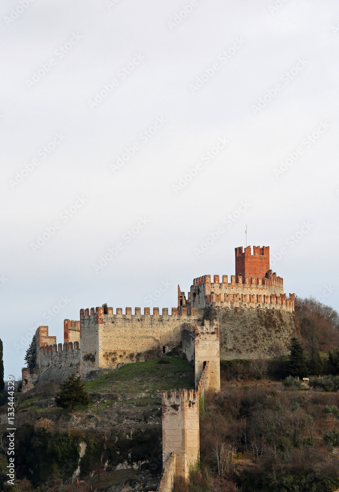Castle of Soave with the medieval walls perched on the hill in t