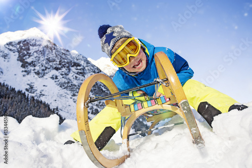 Junge in den Alpen mit Schlitten photo