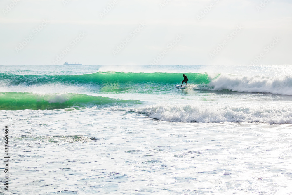 Surfing on turquoise wave in ocean. Sunny day Surfing on turquoise wave in ocean. Sunny day