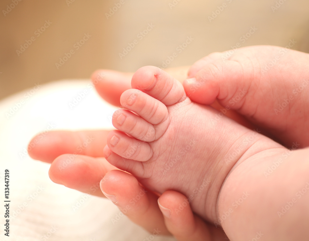 Tiny newborn baby foot in female hands. Tiny newborn baby foot in female hands.