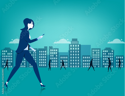 Businesswoman walking on city using a smart phone