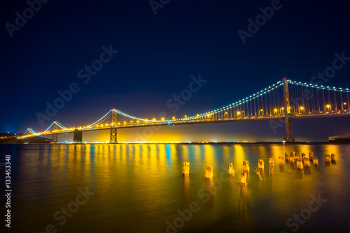 San Francisco Bay Bridge at Night.  Lights reflecting on the water.