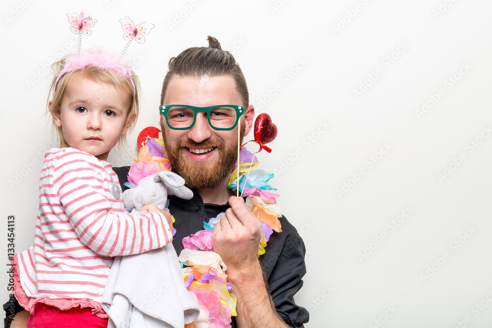 young man and baby happy smile posing on white background with party accessory props photo booth
