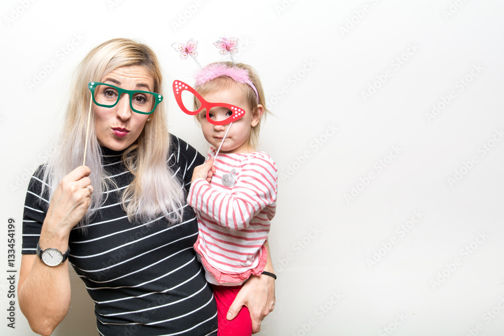 mom and daughter posing on white background party props wedding celebration happy booth
