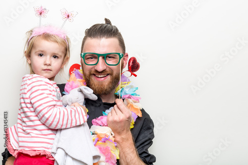 Obraz na płótnie young man and baby happy smile posing on white background with party accessory props photo booth w salonie