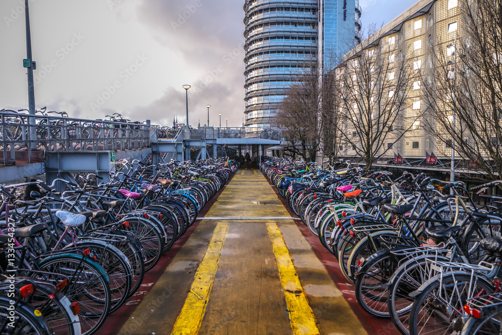 Fototapeta premium AMSTERDAM, NETHERLANDS - JANUARY 10, 2017: Three-level parking of bicycles in Amsterdam city centre. January 10, 2017 in Amsterdam - Netherlands.