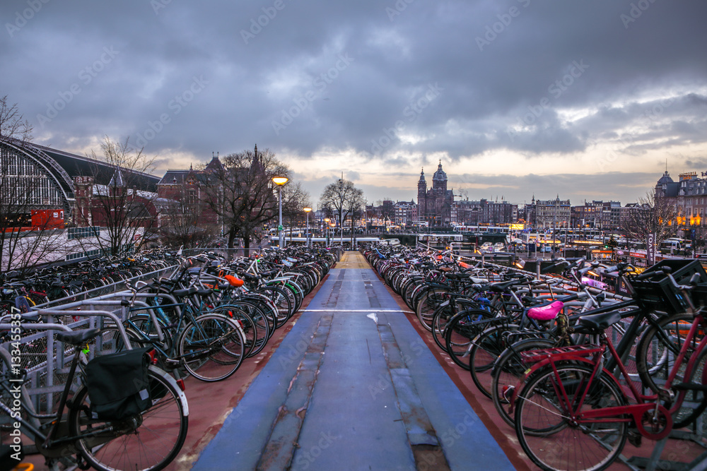 Fototapeta premium AMSTERDAM, NETHERLANDS - JANUARY 10, 2017: Three-level parking of bicycles in Amsterdam city centre. January 10, 2017 in Amsterdam - Netherlands.