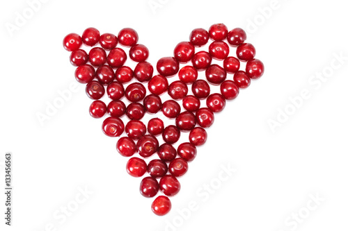 Heart from red fresh cherry.White isolated background.Fruit summer vitamins.Top view.