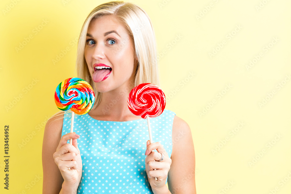 Young woman holding lollipops