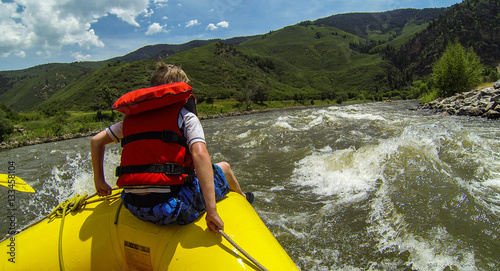 Young Boy rides the Bull during a white water rafting expedition in Glenwood Canyon on the Colorado River