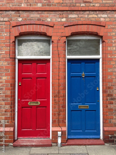 a blue and red door next to each other in a classic English building in cherster, England