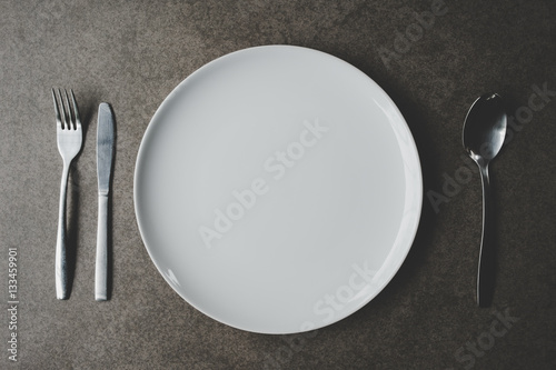 Spoon and Fork Tied on a White Napkin on Wooden Table